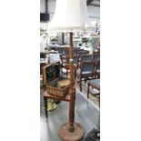 A tall wooden standard lamp and shade