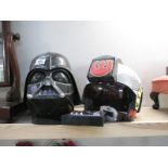 A Darth Vader helmet and another Star Wars helmet
