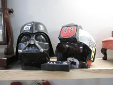 A Darth Vader helmet and another Star Wars helmet