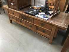 A large rustic teak coffee table with drawer