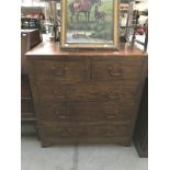 A solid teak chest of drawers with brass handles