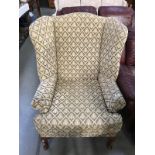 A fabric covered wing armchair with Queen Anne legs