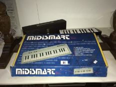 A Hohna Melodica Cassotto 26 and a boxed Midismart keyboard