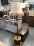 A heavy light oak standard lamp with round base & round lower gallery shelf with shade