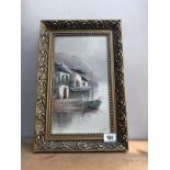 A gilt framed oil on canvas of a boat by buildings