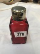 A ruby scent bottle with white metal top