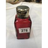 A ruby scent bottle with white metal top