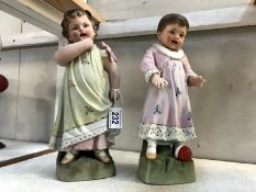 A pair of continental bisque porcelain figures of children (1 a/f)