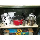 A shelf of kitchen items including a crock pot, electric can opener kettle etc.