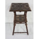 Carved walnut 2 tier occasional table, with circular floral imprints, bobbin shaped upper and
