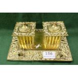 English brass Double Inkwell with decorative borders of foliage and masks, 9”w x 6”d