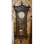 Spring drive Vienna double weight Wall Clock in a decorative walnut case with ebony finials, 51”h