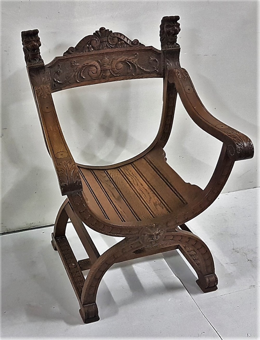 Oak “Throne” Armchair with lion mask finials, with carved panel on C shaped base and carved