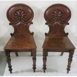 Matching pair of mahogany Hall Chairs, with shield shape back and athemium decoration, turned