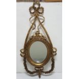 Continental carved wood Wall Mirror with decorative ribbon shaped pediment, bevelled oval insert,