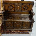 Victorian carved oak Monk’s Bench, the hinged top opening to reveal 2 lion shaped bench arms and a