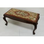 A carved walnut duet/window stool with needlepoint seat, on cabriole supports 40" wide