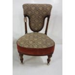 A Victorian walnut low seat nursing chair with shaped seat and back, on turned & flutes supports