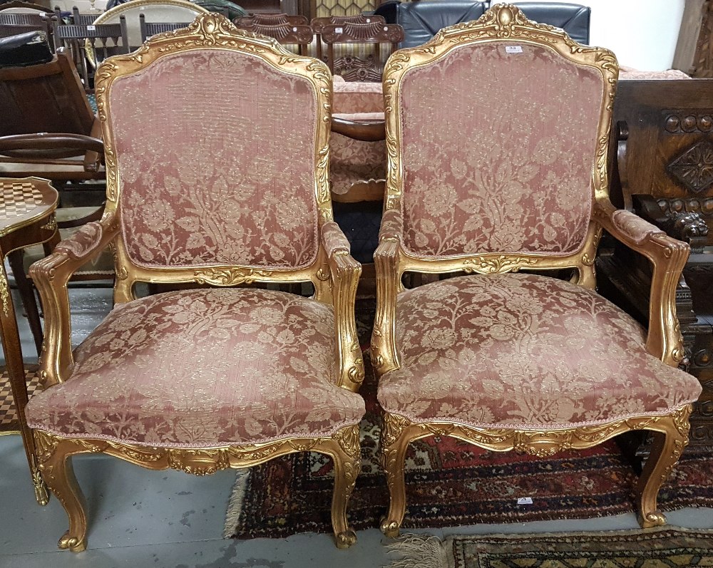 Matching Pair of carved Gilt Wood Framed Armchairs, the backs and seats covered with red and gold