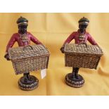Pair of standing Porter Figures, each holding a gilt basket, 23cm h (2)