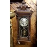 Early 20th century continental beechwood Vienna style wall clock with a carved surmount decorated