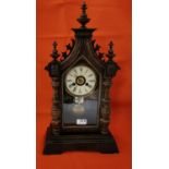 American Ansonia Mantel Clock in a walnut and gothic influenced case, with a visible bell and a 24-