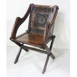 An oak Glastonbury style chair with leaf sidearm's, chessboard decorated seat, 86cm h x 50cm w