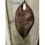 An old large African shield, oval shaped, painted with red patterns, 102cm h x 50cm w