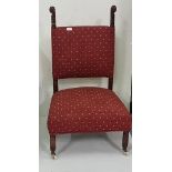 19th C upholstered low chair with extended back supports, red fabric upholstery, porcelain castors
