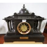 Mantel Clock with 4 doric columns and a black face with gold numerals, also a brass presentation