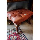Pair of upholstered mahogany footstools resting on cabriole legs.