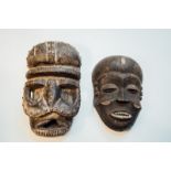 Two African masks, one decorated with white patina.