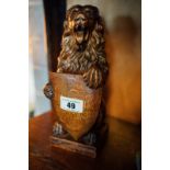 Hand carved newel post in the form of a seated lion with shield.