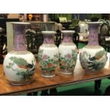 Ex The Doyle Collection A tall pair of famille rose vases with peacocks and a smaller pair the