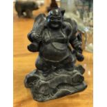 Patinated metal Buddha on a rocky base 12" x 16" H