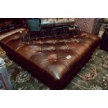 Excpetional quality leather chesterfield footstool raised on turned mahogany legs and brass casters.