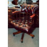 Mahogany and leather ox blood revolving desk chair.