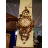 Decorative gilt wall clock in the Georgian style.(60 cm h x 32 cm w).