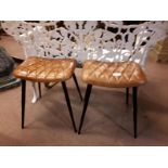 Pair of tanned leather stools with four metal feet. (39 cm h).