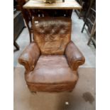 Late 19th. C. leather upholstered armchair on turned legs.