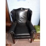 Pair of early 20th. C. black leather wingback chairs with brass studs.