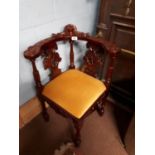 Carved mahogany upholstered corner chair.