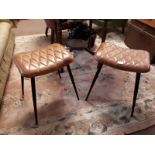 Pair of tanned leather and metal stools with four out turned legs. (47 cm h x 49 cm w).