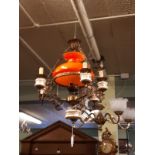 Pair of brass and porcelain chandeliers with original red glass shade.