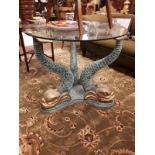 Decorative centre table the circular glass top supported by three bronze dolphins.