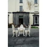 Cast iron garden table and three chairs decorated with rams heads. { 64cm H X 65 cm D }.