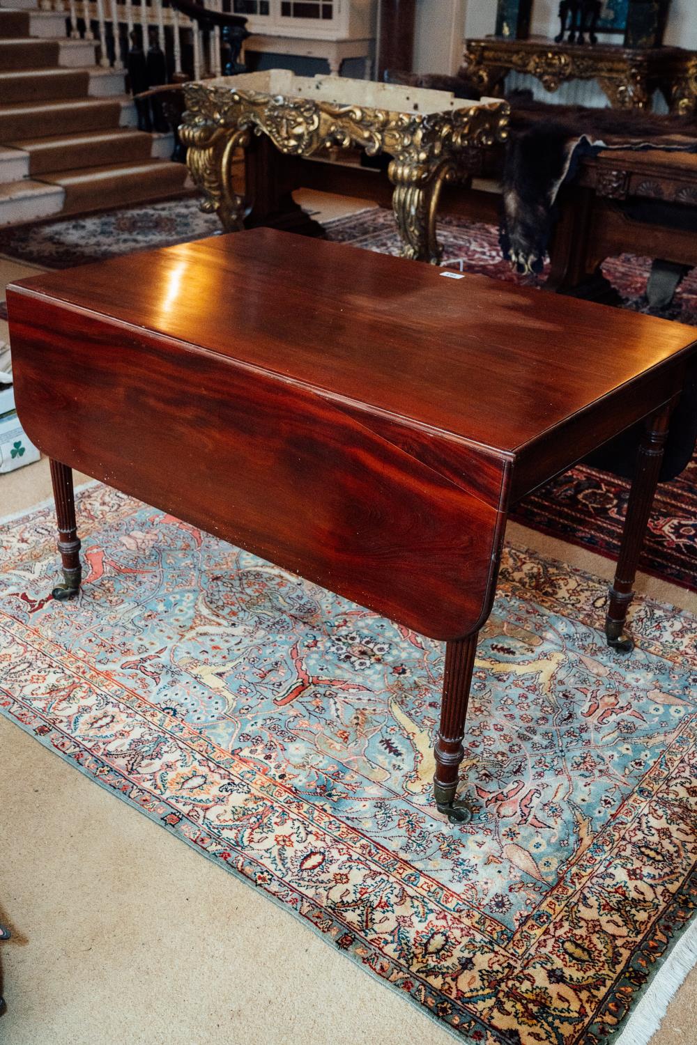 Georgian mahogany Pembroke table raised on reeded legs withn brass casters. { 72cm H X 113 cm W X