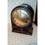 Early 20th. C. tortoise shell mantle clock with brass dial. { 15cm H }.