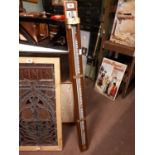 Mahogany and brass measuring stick {139 cm H}.