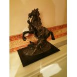 Bronze figure of a man holding a horse mounted on a marble base. { 30cm H X 28cm H X16cm D }.